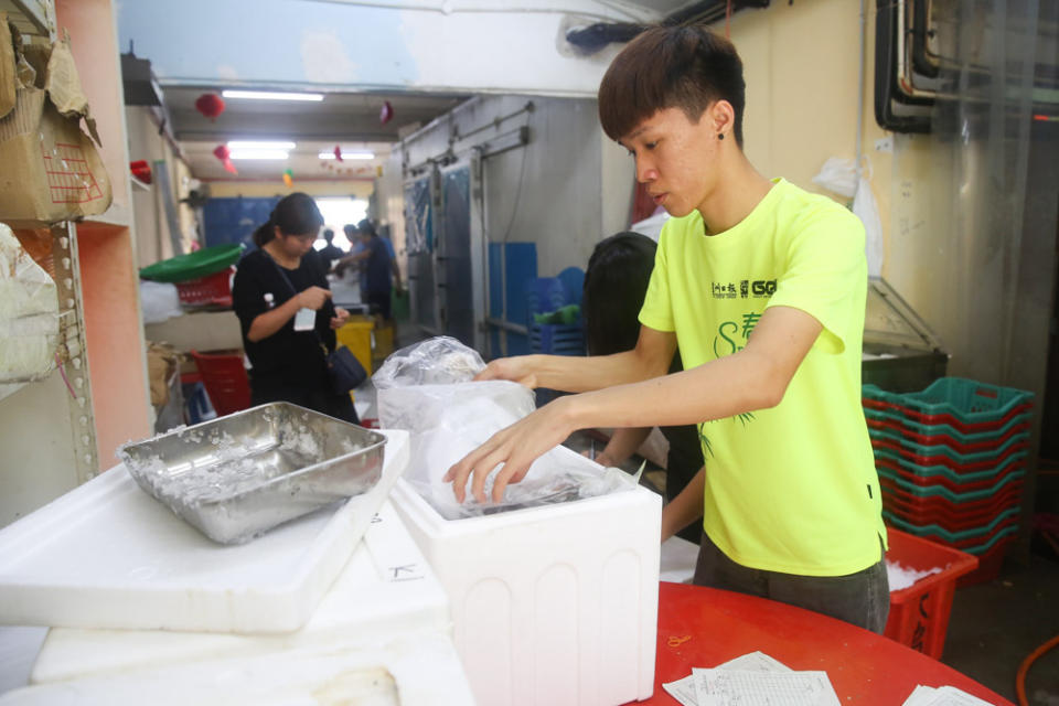 A worker packs the sold fish from the 'live' auction for delivery. — Picture by Choo Choy May