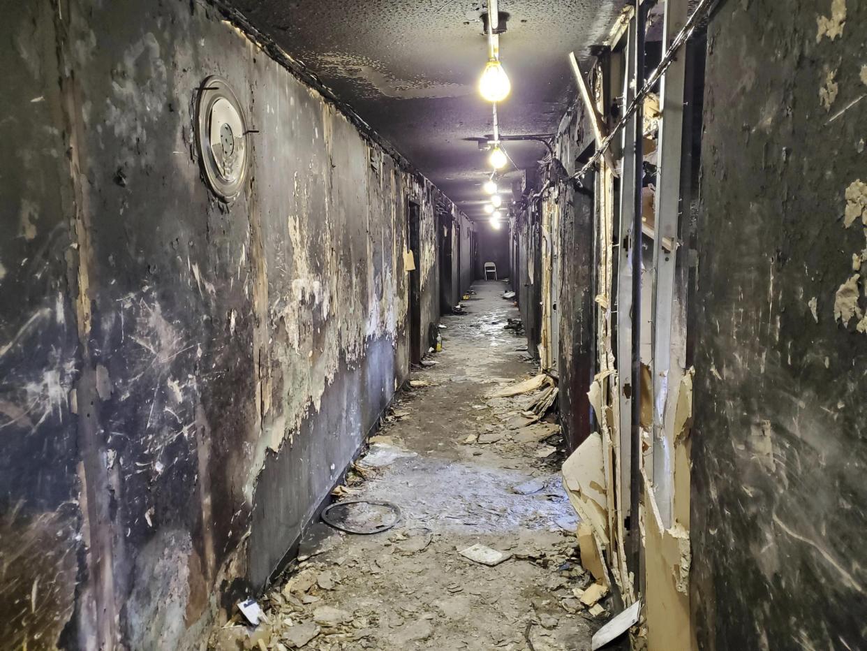 This photo provided by the NYC Department of Buildings shows charred walls and debris in a third-floor hallway at the Bronx apartment building which suffered a fatal fire in the Bronx, New York on Jan. 9, 2022. 