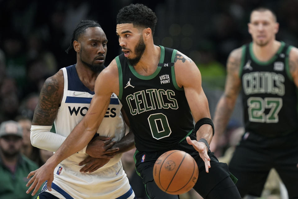 Boston Celtics forward Jayson Tatum (0) looks for an opening past Minnesota Timberwolves guard Jaylen Nowell (4), left, in the second half of an NBA basketball game, Sunday, March 27, 2022, in Boston. (AP Photo/Steven Senne)