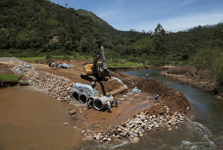 Workers fix pipes on the banks of Muthirapuzha River as they construct a temporary bridge in Munnar, Kerala, India, September 6, 2018. REUTERS/Sivaram V