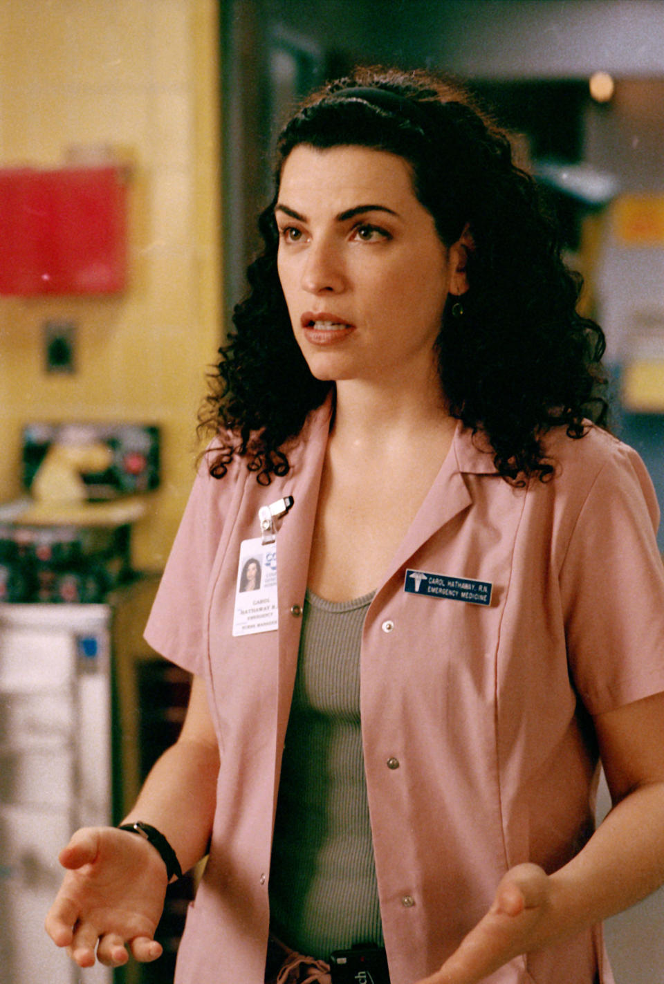 Julianna Margulies as Nurse Carol Hathaway in a scene from the TV show "ER," wearing scrubs and a badge