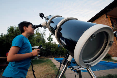 Ricardo Barriga, 10, observes the moon with his telescope in his home in Pirque, Chile January 16, 2019. Picture taken January 16, 2019. REUTERS/Rodrigo Garrido
