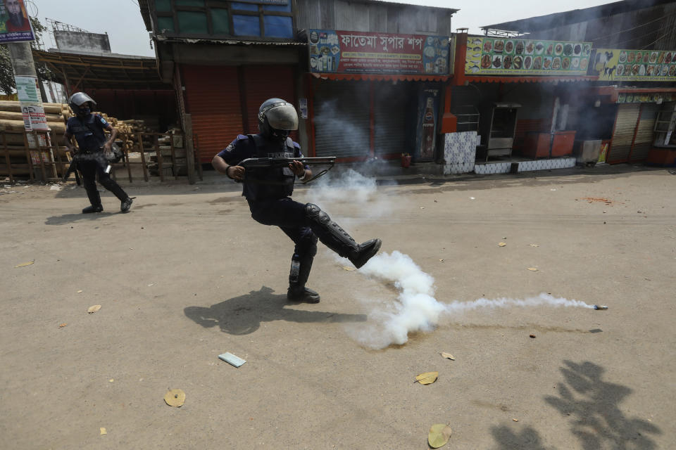 A Bangladeshi policeman kicks away a tear gas shell that misfired while trying to disperse activists of Bangladesh Islamist group Hefazat-e-Islam, enforcing a daylong general strike in Narayanganj, Bangladesh, Sunday, March 28, 2021. The Islamist group having a strong network of Islamic schools had called for the strike to denounce the deaths of four people in clashes with police involving the visit of Indian Prime Minister Narendra Modi. (AP Photo/Mahmud Hossain Opu)