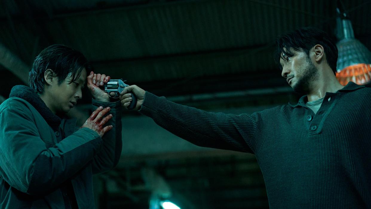  Jang Nan-gam (Son Suk-ku) with a gun to Lee Tang's (Choi Woo-shik) head in Netflix's A Killer Paradox. 