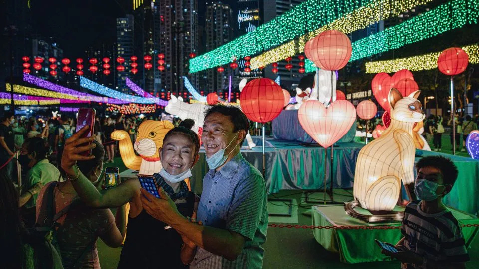 Visitors take selfies in front of light installations at Victoria Park in Hong Kong during the Mid-Autumn Festival in September 2022. - Ryan K. W. Lai/Shutterstock