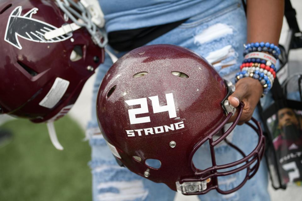 Zenobia Dobson holds a 24 Strong helmet that honors her son's life and legacy at the first annual Zaevion Dobson Foundation Game between Fulton and Austin-East Magnet High School at Fulton High School in Knoxville on Friday.