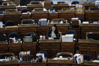 State Rep. Tracy Ehlert, D-Cedar Rapids, works at her desk in the Iowa House, Monday, March 16, 2020, at the Statehouse in Des Moines, Iowa. I Iowa leaders are suspending the current legislative session for at least 30 days in efforts to prevent the spread of COVID-19 coronavirus. (AP Photo/Charlie Neibergall)