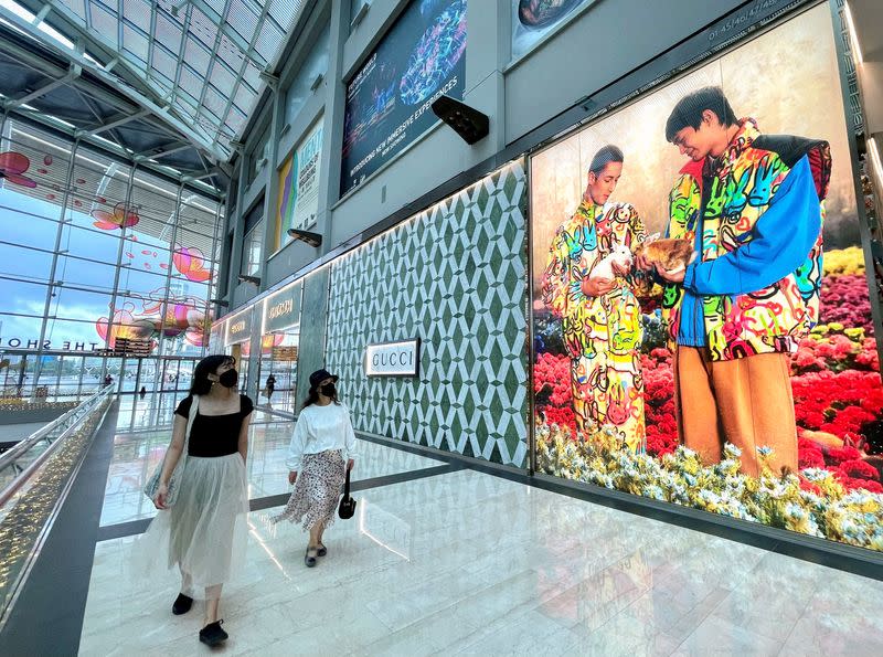 FILE PHOTO: Visitors walk past a Gucci store at Marina Bay Sands in Singapore