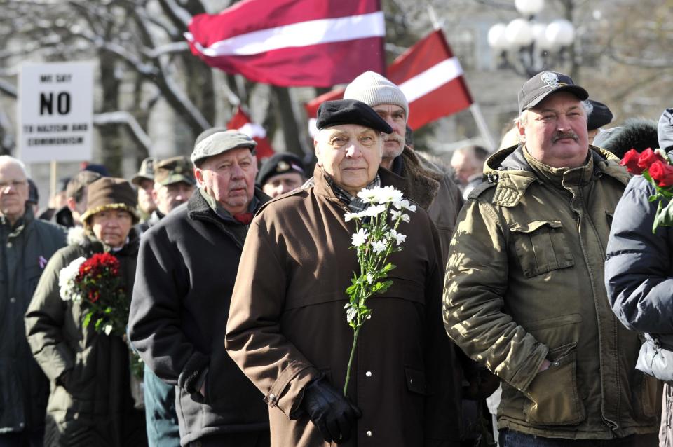 People carry Latvian flags as they march to the Freedom Monument to commemorate World War II veterans who fought in Waffen SS divisions, in Riga, Latvia, Sunday, March 16, 2014. People participate in annual commemorations of Latvian soldiers who fought in Nazi units during WWII. (AP Photo/Roman Kosarov, F64 Photo Agency)