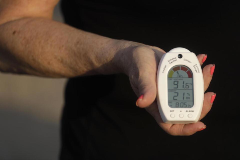 A woman holds a heat and humidity device.