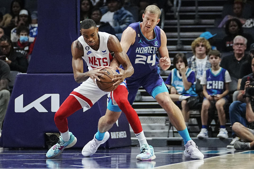 Brooklyn Nets forward Nic Claxton, left, works to retain possession against Charlotte Hornets center Mason Plumlee during the first half of an NBA basketball game, Saturday, Nov. 5, 2022, in Charlotte, N.C. (AP Photo/Rusty Jones)