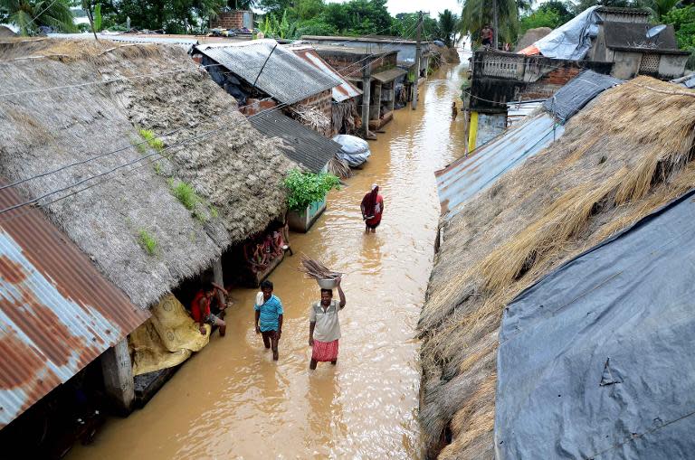 Indian villagers make their way through floodwaters at Kakharubasta in the eastern state of Orissa, on August 7, 2014