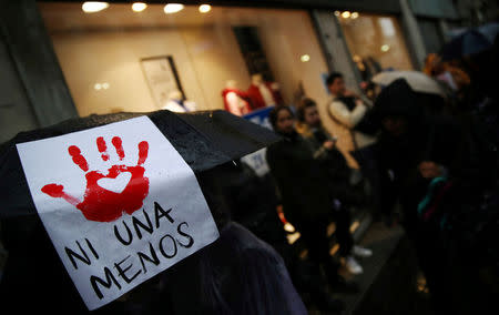 A woman carries a sign that reads "Not another (woman) less" on her umbrella during a demonstration to demand policies to prevent gender-related violence in Buenos Aires, Argentina, October 19, 2016. REUTERS/Marcos Brindicci