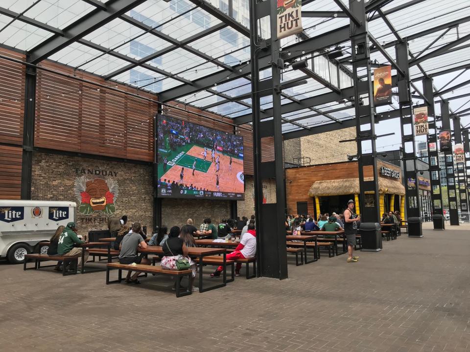 A handful of people watching the Milwaukee Bucks game from The Beer Garden in the Deer District.