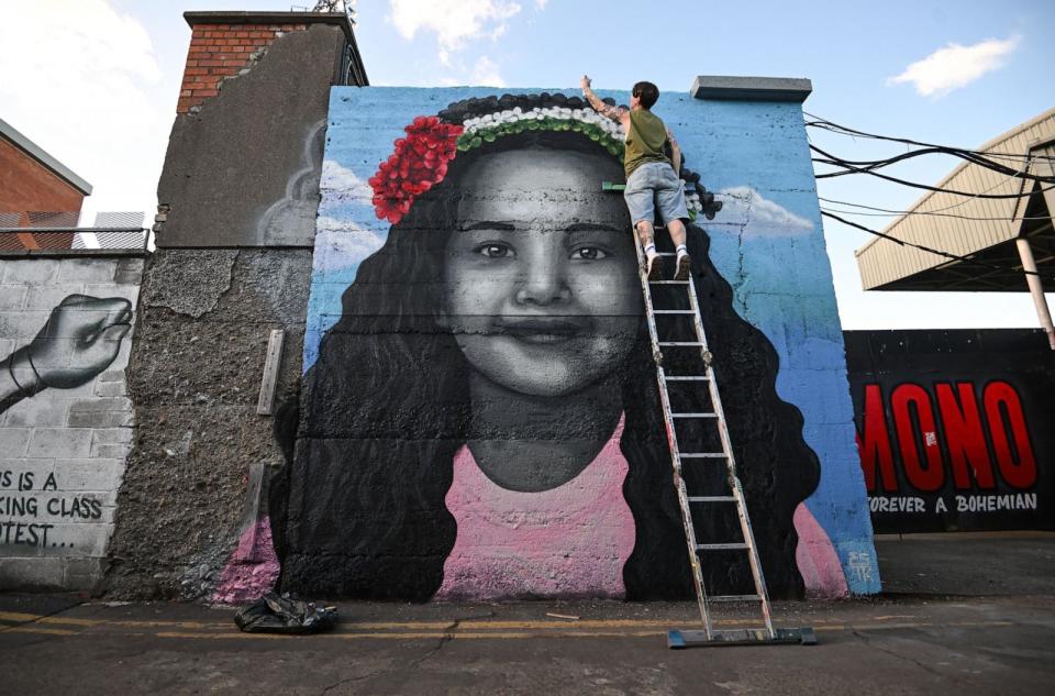 PHOTO: Artist Emmalene Blake puts the final touches to a mural of Hind Rajab, the 6-year-old Palestinian girl who was killed in Gaza, along with several family members and paramedics, in Dublin, Ireland, May 15, 2024. (Stephen Mccarthy/Sportsfile via Getty Images)