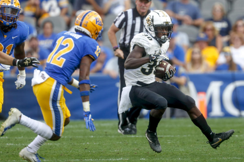 Central Florida running back Greg McCrae (30) tries to evade Pittsburgh defensive back Paris Ford (12) on a ruin during the first half of an NCAA college football game, Saturday, Sept. 21, 2019, in Pittsburgh. (AP Photo/Keith Srakocic)