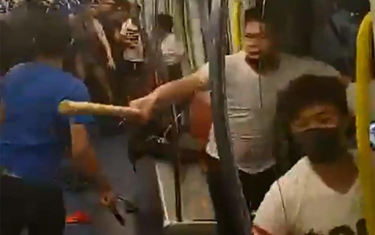 Screenshot of the moment men in white shirts began beating commuters on a train in Hong Kong. Many of the victims had taken part in a pro-democracy protest earlier that day  - AFP