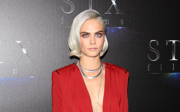 Cara Delevingne debuts her shaved head on the Met Gala red carpet — and it’s silver