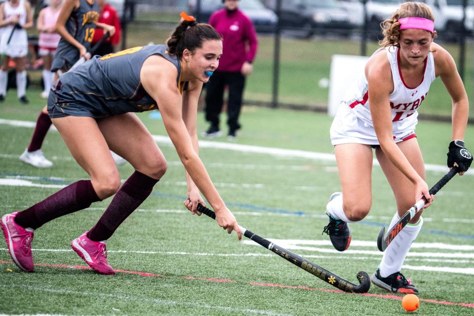 Milford sophomores Hannah Zimmerman (9) and Smyrna junior Dru Moffett (11) battle for the ball during the field hockey game at Smyrna, Tuesday, Oct. 25, 2022. Smyrna won 3-0.