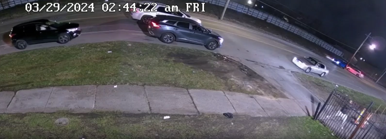 A man can be seen in the bottom right of this image from security footage appearing to hold a gun as he fires at a group of people early Friday morning in the parking lot of a bar in Detroit following an argument over a parking spot, Detroit police said.
