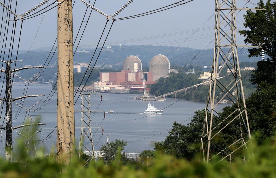 Older electricity transmission towers like the one at far right will be replaced across New York with modern steel poles like the ones at left. The Indian Point power plant can be seen in the background in this view from Tomkins Cove on July 27, 2021.