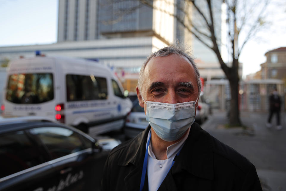 Dr. Philippe Montravers speaks with The Associated Press at the main entrance of the Bichat Hospital, in Paris on Tuesday, Nov. 10, 2020. Montravers and the 150 doctors and nurses he leads have become experts about how to treat COVID-19. That knowledge is proving invaluable against a second deadly surge of the virus is again threatening to overwhelm European health systems. (AP Photo/Francois Mori)