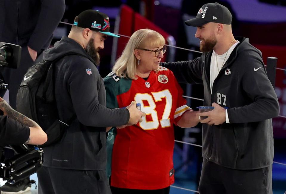 donna kelce gives cookies to her sons jason kelce of the philadelphia eagles and travis kelce of the kansas city chiefs during super bowl lvii opening night on february 6