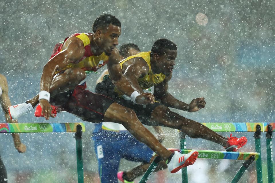 <p>Orlando Ortega of Spain and Deuce Carter of Jamaica compete in the rain during the Men’s 110m Hurdles Round 1 – Heat 2 on Day 10 of the Rio 2016 Olympic Games at the Olympic Stadium on August 15, 2016 in Rio de Janeiro, Brazil. (Getty) </p>