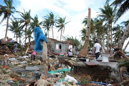 Residents are seen among debris and damaged houses after strong winds and heavy rains brought by typhoon Melor battered Barcelona town, Sorsogon province, central Philippines December 15, 2015. REUTERS/Renelyn Loquinario