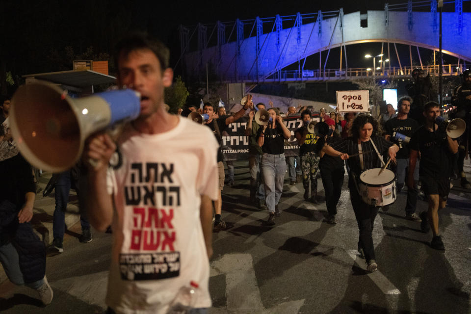 People take part in a protest against Israeli Prime Minister Benjamin Netanyahu's government and call for the release of hostages held in the Gaza Strip by the Hamas militant group outside of the Knesset, Israel's parliament, in Jerusalem, Monday, April 1, 2024. (AP Photo/Leo Correa)