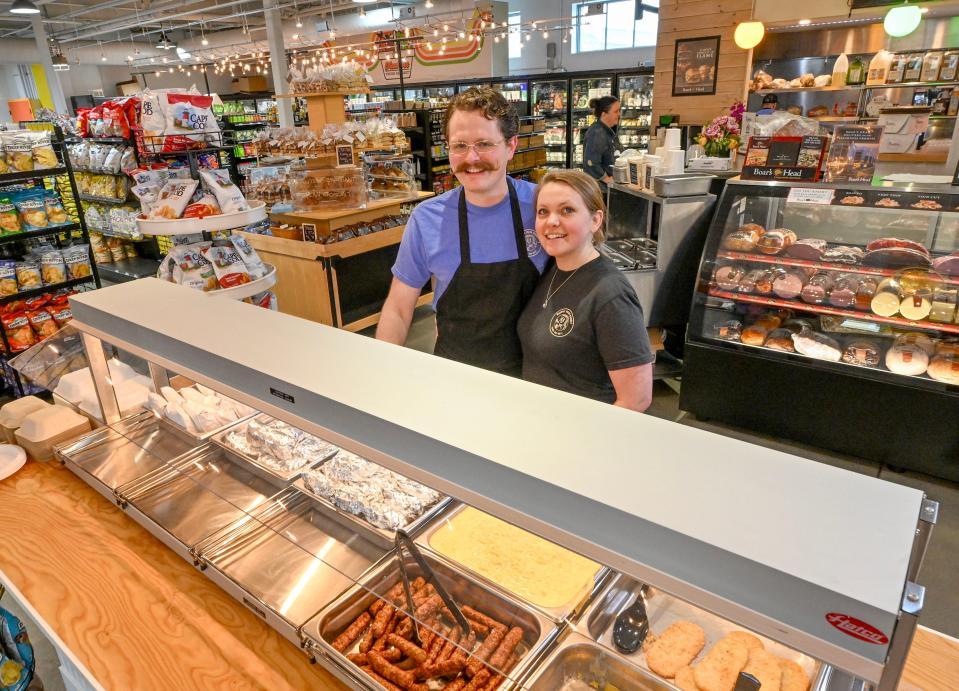 Owners Seth and Megan Burdick next to their hot food bar at Mashpee Fresh Market in Mashpee Commons.