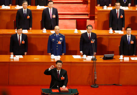 Chinese President Xi Jinping pledges an oath to the Constitution after being confirmed president for another term during the fifth plenary session of the National People's Congress (NPC) at the Great Hall of the People in Beijing, China March 17, 2018. REUTERS/Thomas Peter