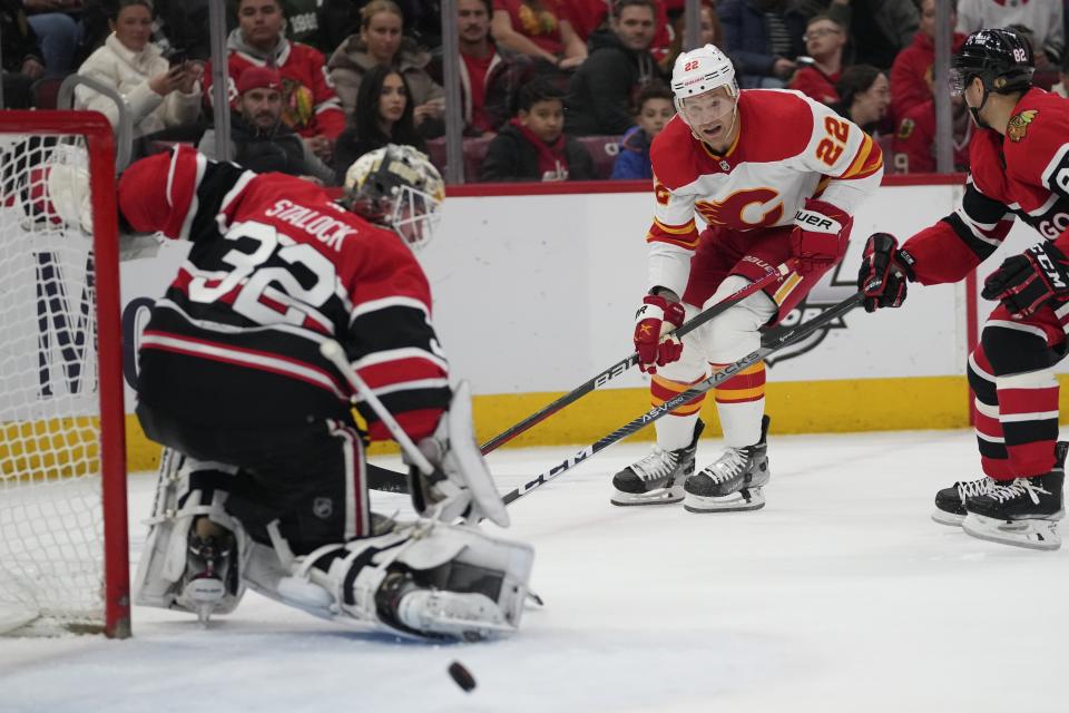 Calgary Flames center Trevor Lewis' (22) is deflected by Chicago Blackhawks goaltender Alex Stalock (32) during the second period of an NHL hockey game, Sunday, Jan. 8, 2023, in Chicago. (AP Photo/Erin Hooley)