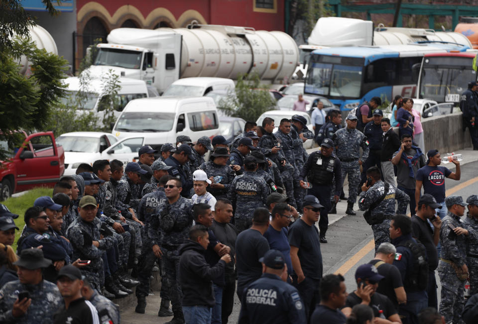 Uniformed federal police block the highway between Mexico City and Pachuca in both directions, in Ecatepec, Mexico, Wednesday, July 3, 2019. Hundreds of Mexican federal police were in open revolt Wednesday against plans to absorb them into the newly formed National Guard.(AP Photo/Rebecca Blackwell)