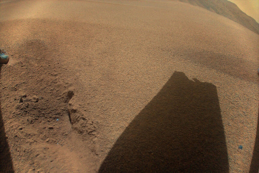 The shadow of a rotor blade of NASA’s Ingenuity Mars Helicopter