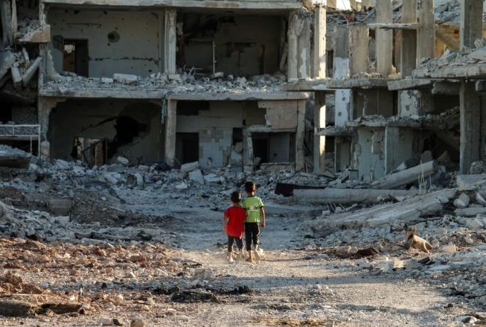 Syrian children walk through the ruins of a rebel-held neighbourhood of the southern city of Daraa, on September 6, 2017 (AFP Photo/Mohamad ABAZEED)