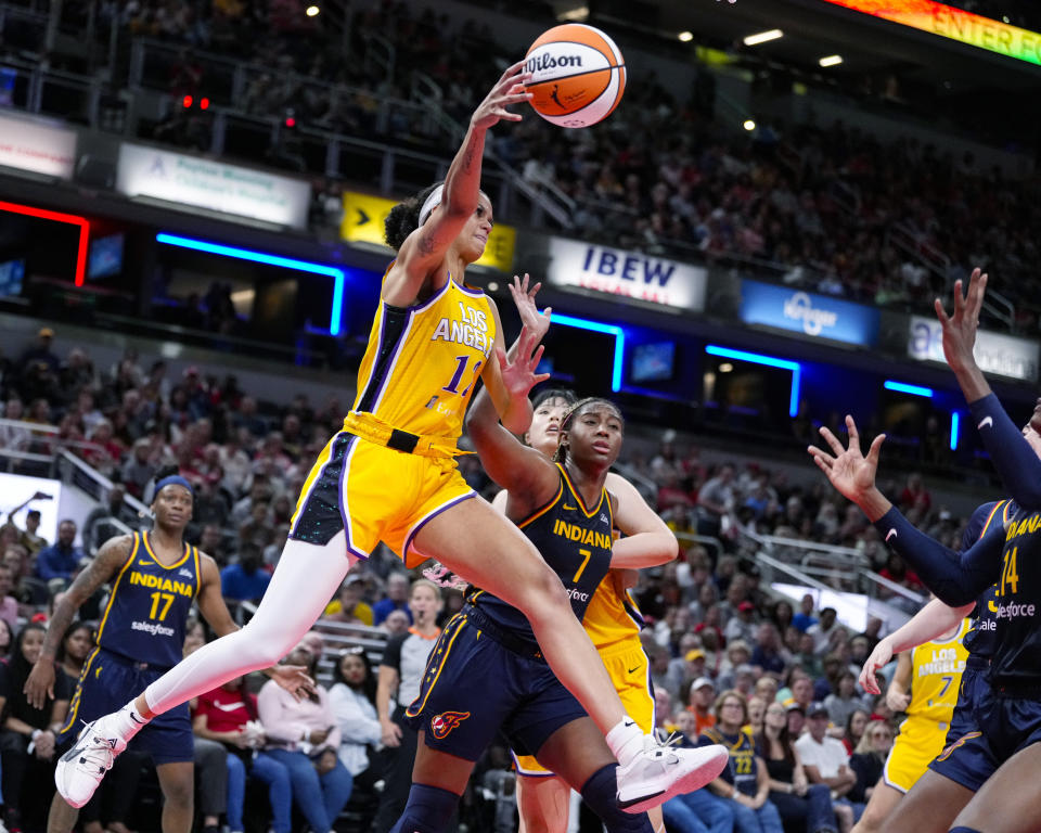 Los Angeles Sparks guard Rae Burrell (12) passes the ball in front of Indiana Fever forward Aliyah Boston (7) during the second half of a WNBA basketball game in Indianapolis, Tuesday, May 28, 2024. (AP Photo/Michael Conroy)