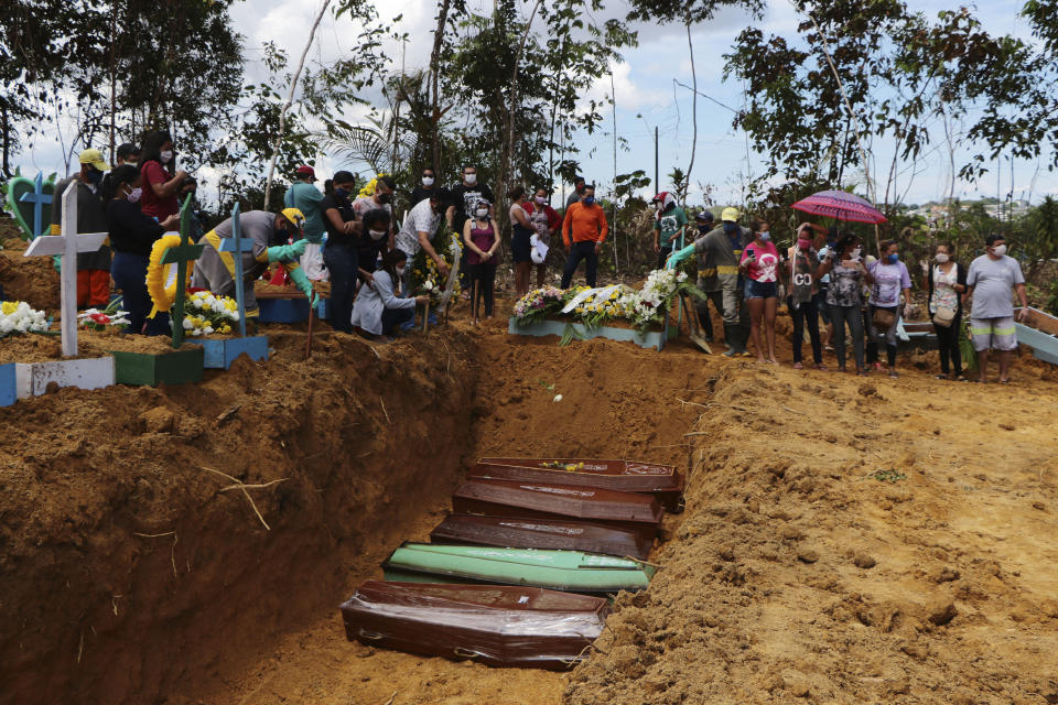 Relatives mourn at the site of a mass burial at the Nossa Senhora Aparecida cemetery, in Manaus, Amazonas state, Brazil, Tuesday, April 21, 2020. The cemetery is carrying out burials in common graves due to the large number of deaths from COVID-19 disease, according to a cemetery official. (AP Photo/Edmar Barros)