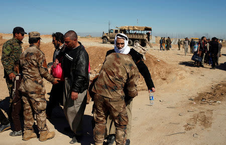 Displaced people are checked by Iraqi forces as Iraqi forces battle with Islamic State militants, in western Mosul, Iraq March 25, 2017. REUTERS/Suhaib Salem