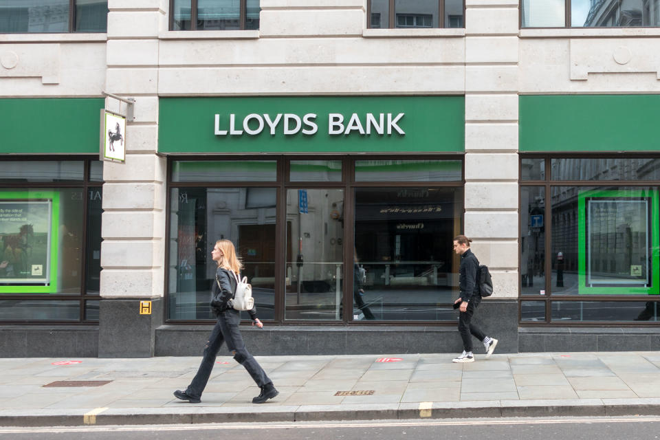 People walk past a Lloyds Bank branch in London