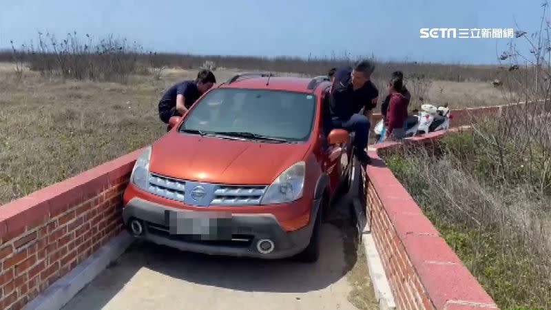 轎車卡在窄小的車道動彈不得。