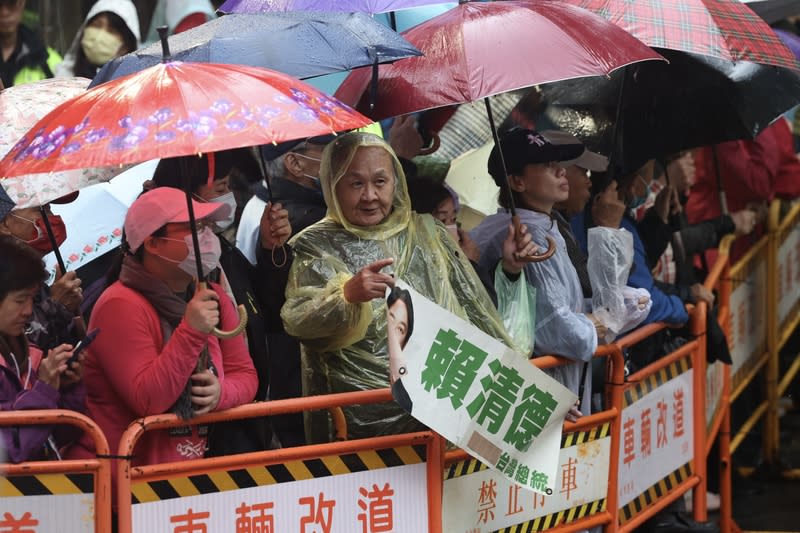 賴清德艋舺青山宮參香　民眾舉看板相挺 民進黨總統參選人賴清德4日前往艋舺青山宮參香， 有支持者穿著雨衣持看板為賴清德加油。 中央社記者吳家昇攝  112年12月4日 