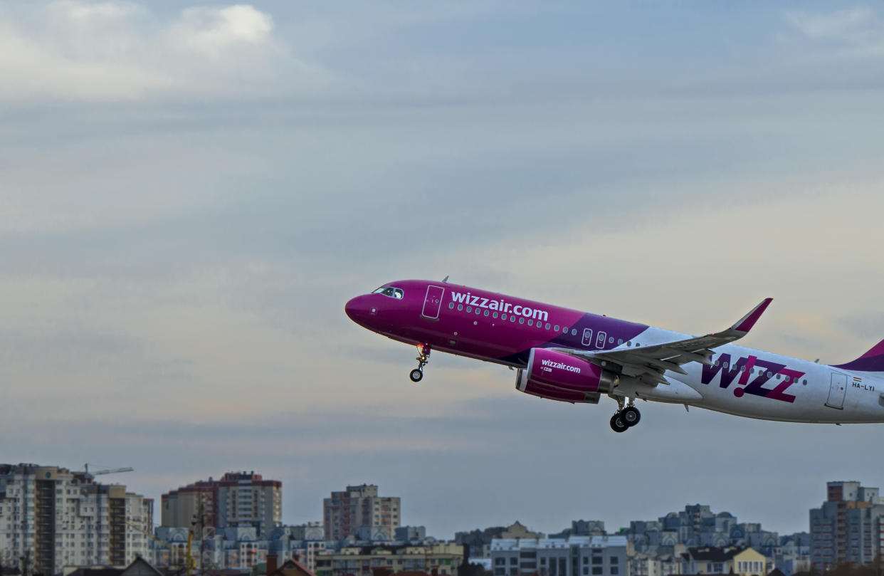 Kiev, Ukraine, March 7, 2019. Multicolored airplane company Wizzair comes to take over houses against a backdrop of blue sky in the city