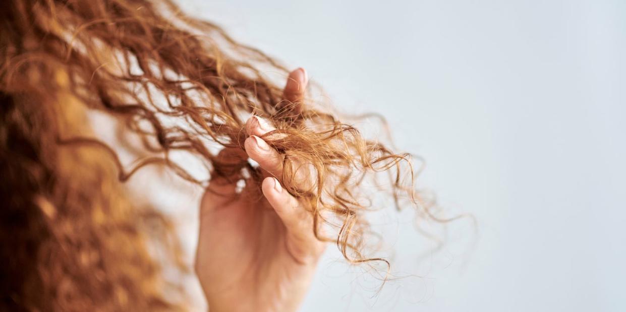 woman running fingers through curly hair