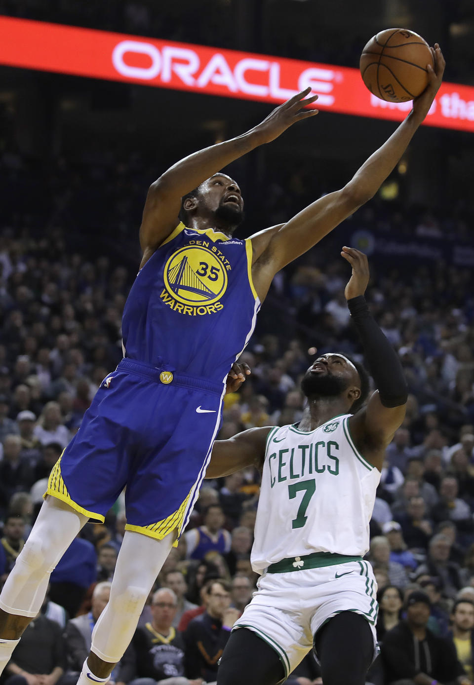 Golden State Warriors' Kevin Durant shoots in front of Boston Celtics' Jaylen Brown (7) during the first half of an NBA basketball game Tuesday, March 5, 2019, in Oakland, Calif. (AP Photo/Ben Margot)
