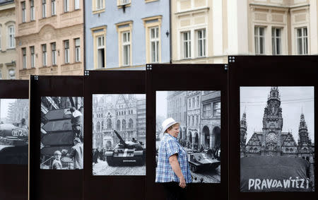 A woman looks at a pictures, commemorating the 50th anniversary of the Soviet-led invasion into former Czechoslovakia, placed on a street in Liberec, Czech Republic, August 21, 2018. REUTERS/David W Cerny