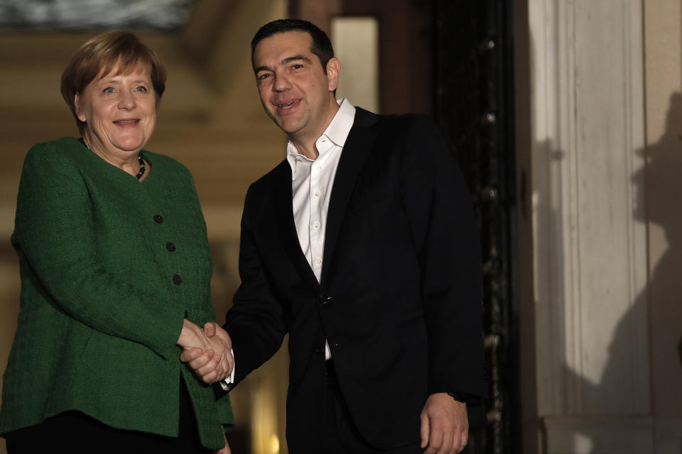 Greek Prime Minister Alexis Tsipras, right, shakes hands with German Chancellor Angela Merkel during a welcome ceremony in Athens, Thursday Jan. 10, 2019. Merkel is in Greece for talks. (AP Photo/Thanassis Stavrakis)