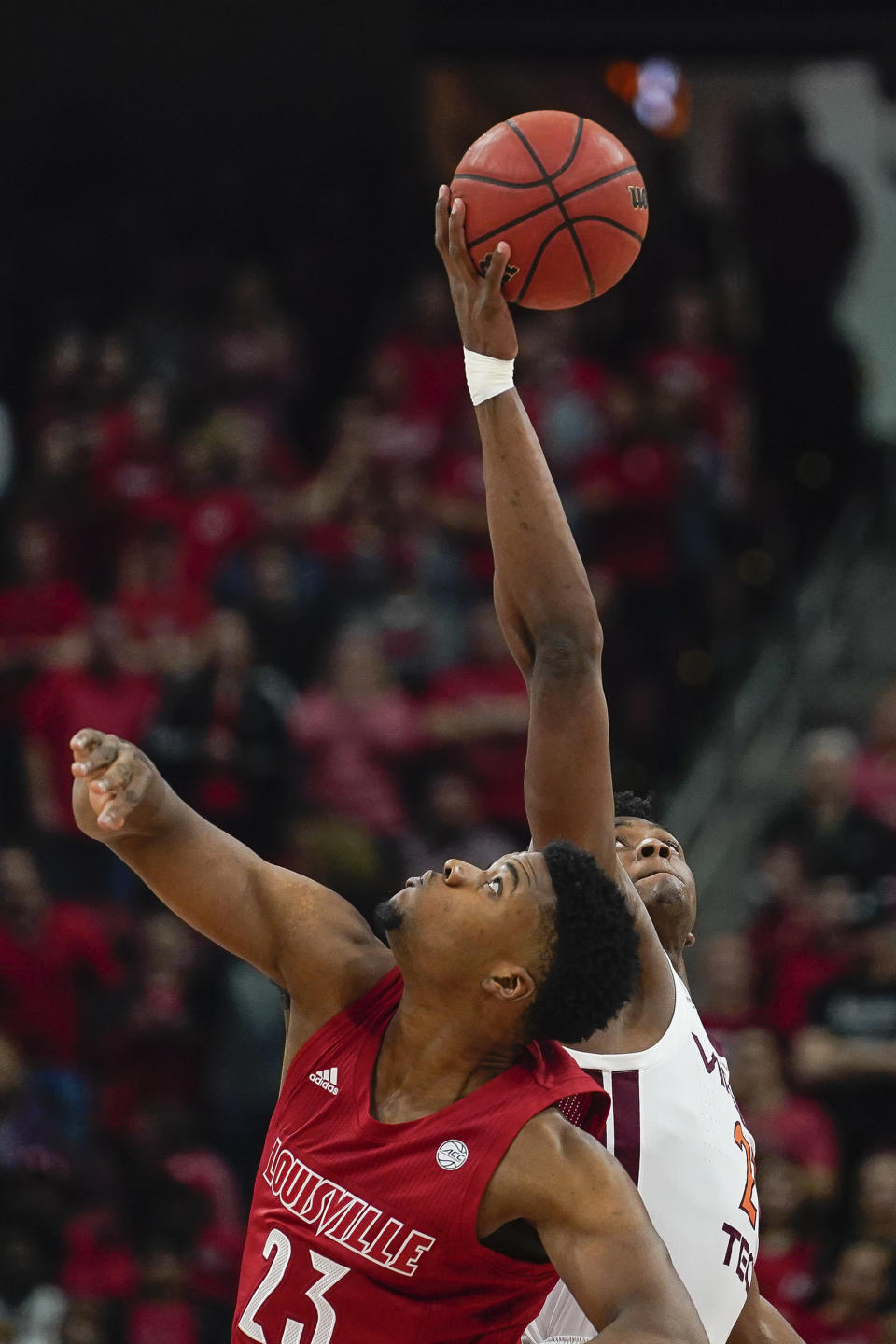 Virginia Tech guard Landers Nolley II (2) and Louisville center Steven Enoch (23) battle for the tip-off at the start of an NCAA college basketball game, Sunday, March 1, 2020, in Louisville, Ky. (AP Photo/Bryan Woolston)