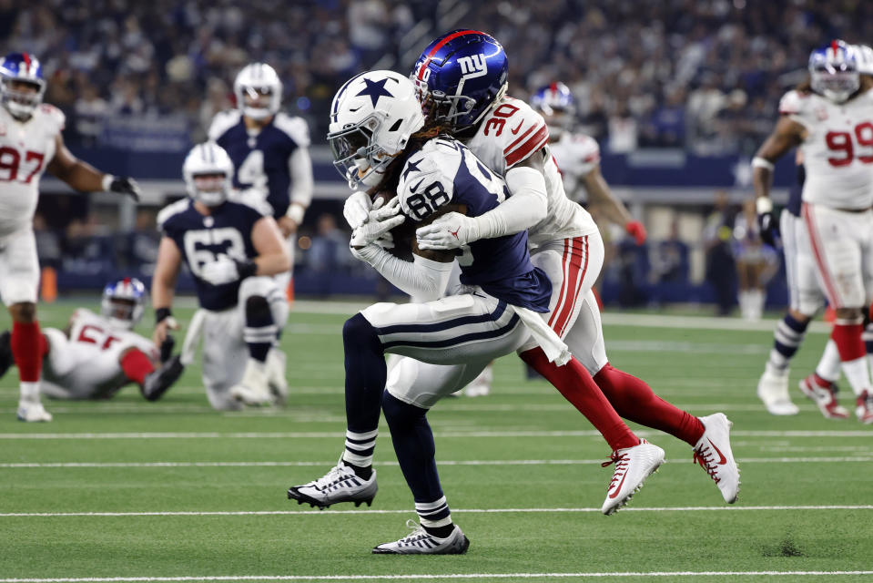 Dallas Cowboys wide receiver CeeDee Lamb (88) catches a pass as New York Giants cornerback Darnay Holmes (30) defends during the second half of an NFL football game Thursday, Nov. 24, 2022, in Arlington, Texas. (AP Photo/Michael Ainsworth)