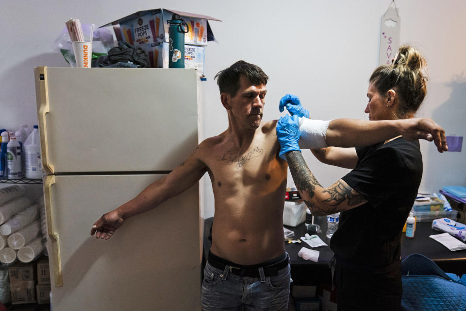 Volunteer registered nurse Jennifer D'Angelo treats Nick Gallagher's skin wounds at the Savage Sisters' community outreach storefront in Philadelphia on May 24, 2023.  (Matt Rourke / AP file)